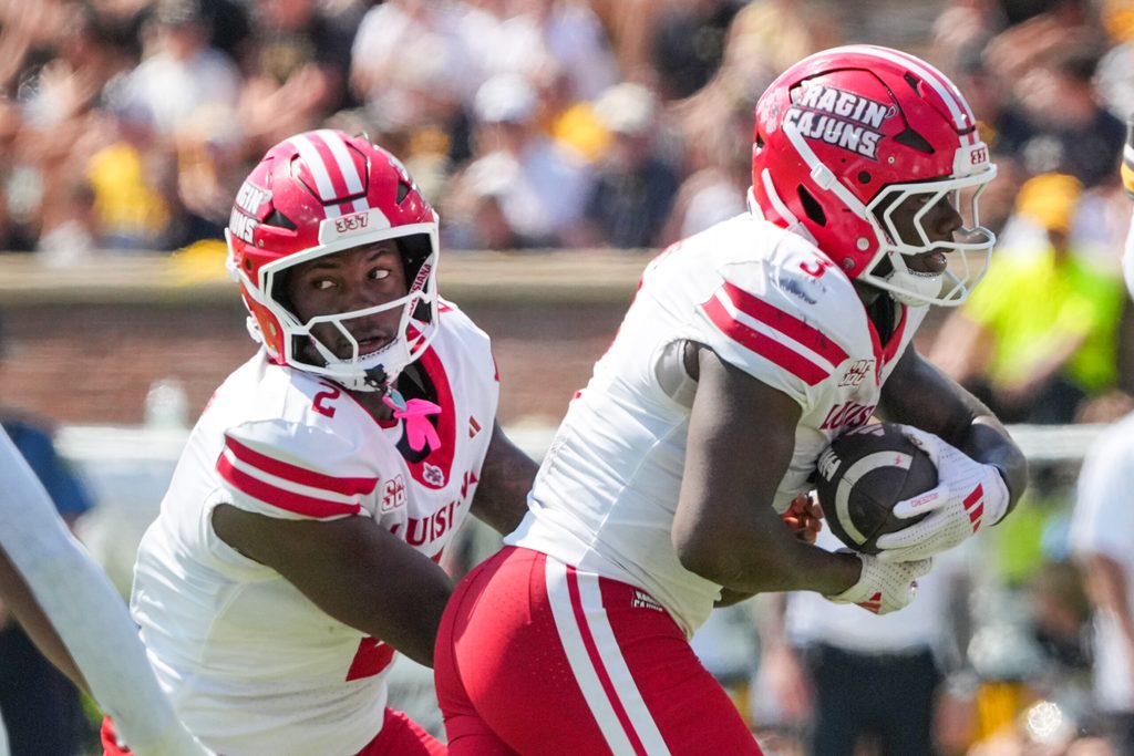 Sep 13, 2025; Columbia, Missouri, USA; Louisiana-Lafayette Ragin Cajuns quarterback Lunch Winfield (2) hands off to running back Zylan Perry (3) against the Missouri Tigers during the first half of the game at Faurot Field at Memorial Stadium. Mandatory Credit: Denny Medley-Imagn Images