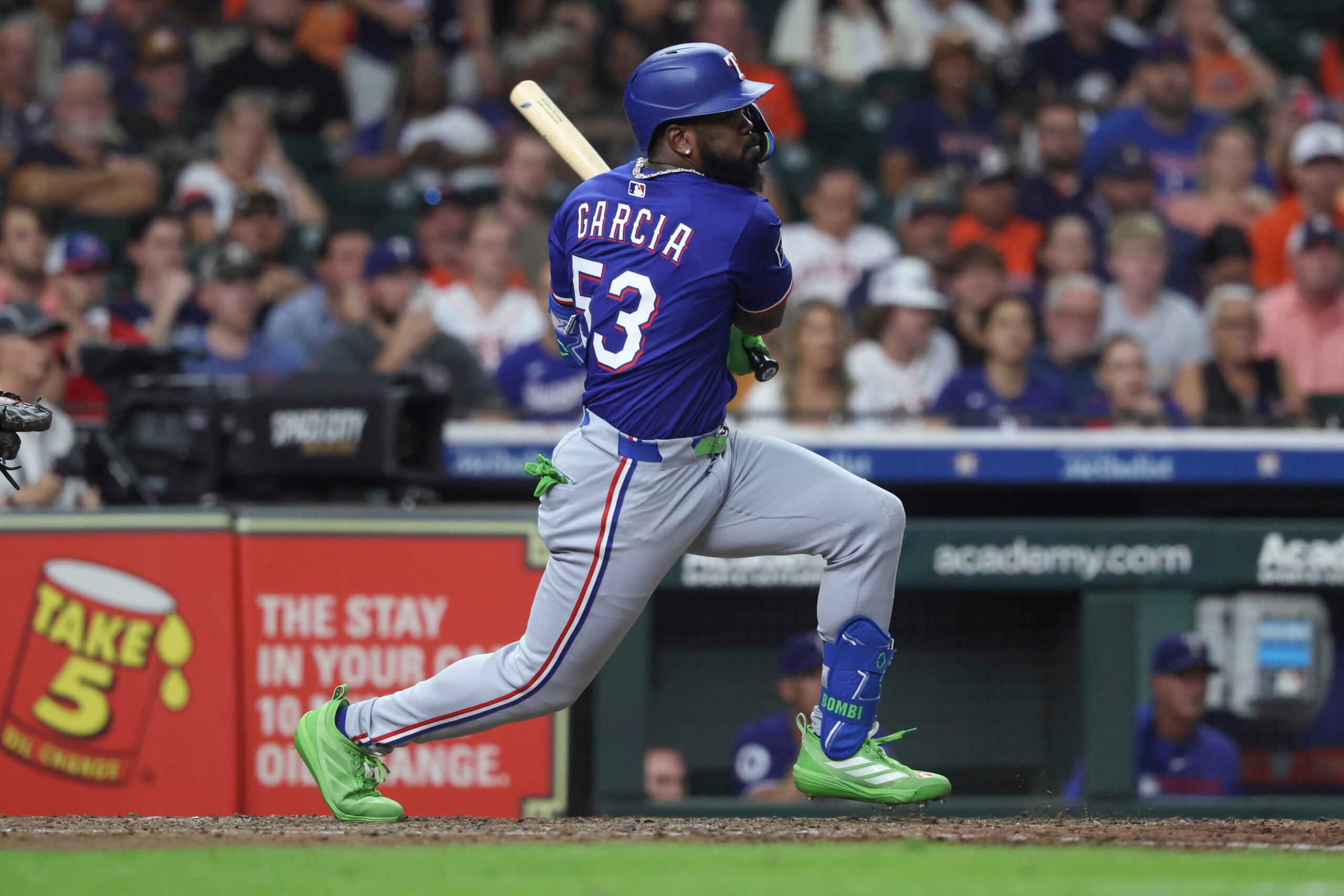 Sep 16, 2025; Houston, Texas, USA; Texas Rangers pinch hitter Adolis Garcia hits an RBI single during the eighth inning against the Houston Astros at Daikin Park. Mandatory Credit: Troy Taormina-Imagn Images