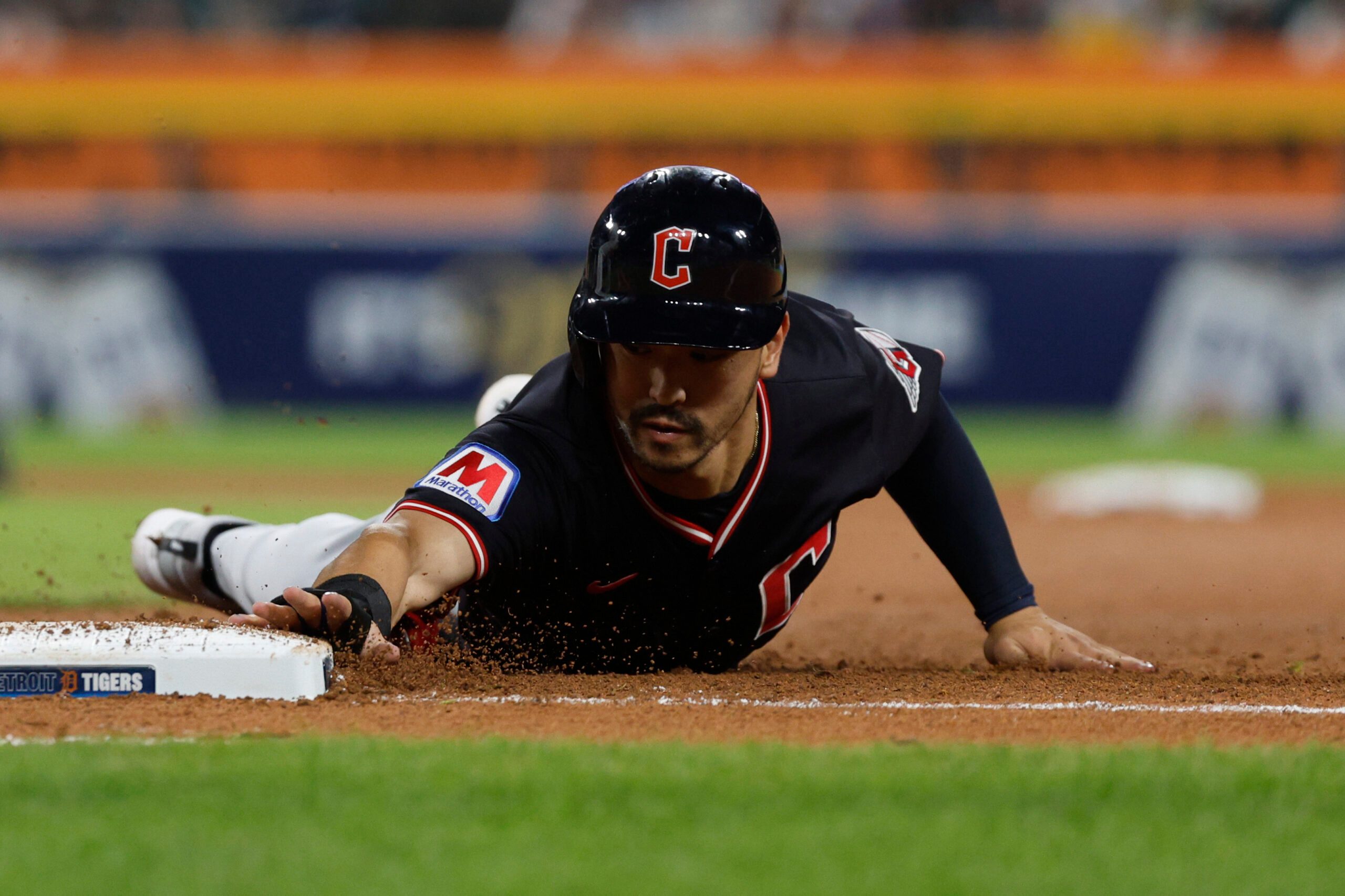 Sep 17, 2025; Detroit, Michigan, USA; Cleveland Guardians left fielder Steven Kwan (38) slides into first base after trying to steal second base during the eighth inning against the Detroit Tigers at Comerica Park. Mandatory Credit: Brian Bradshaw Sevald-Imagn Images