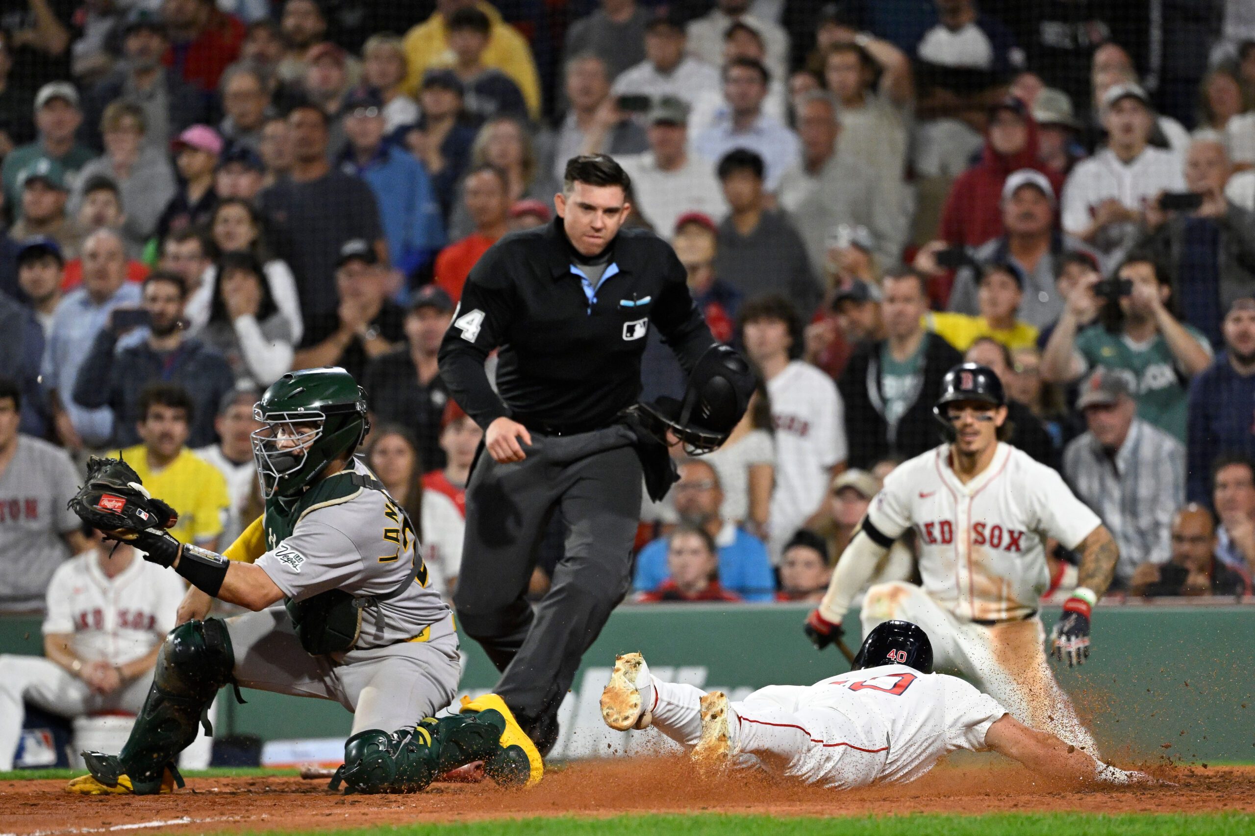 Sep 17, 2025; Boston, Massachusetts, USA; Boston Red Sox third baseman Nate Eaton (40) slides across home plate against Athletics catcher Shea Langeliers (23) to score the winning run off an RBI by first baseman Nick Sogard (20) (not pictured) during the tenth inning at Fenway Park. Mandatory Credit: Eric Canha-Imagn Images