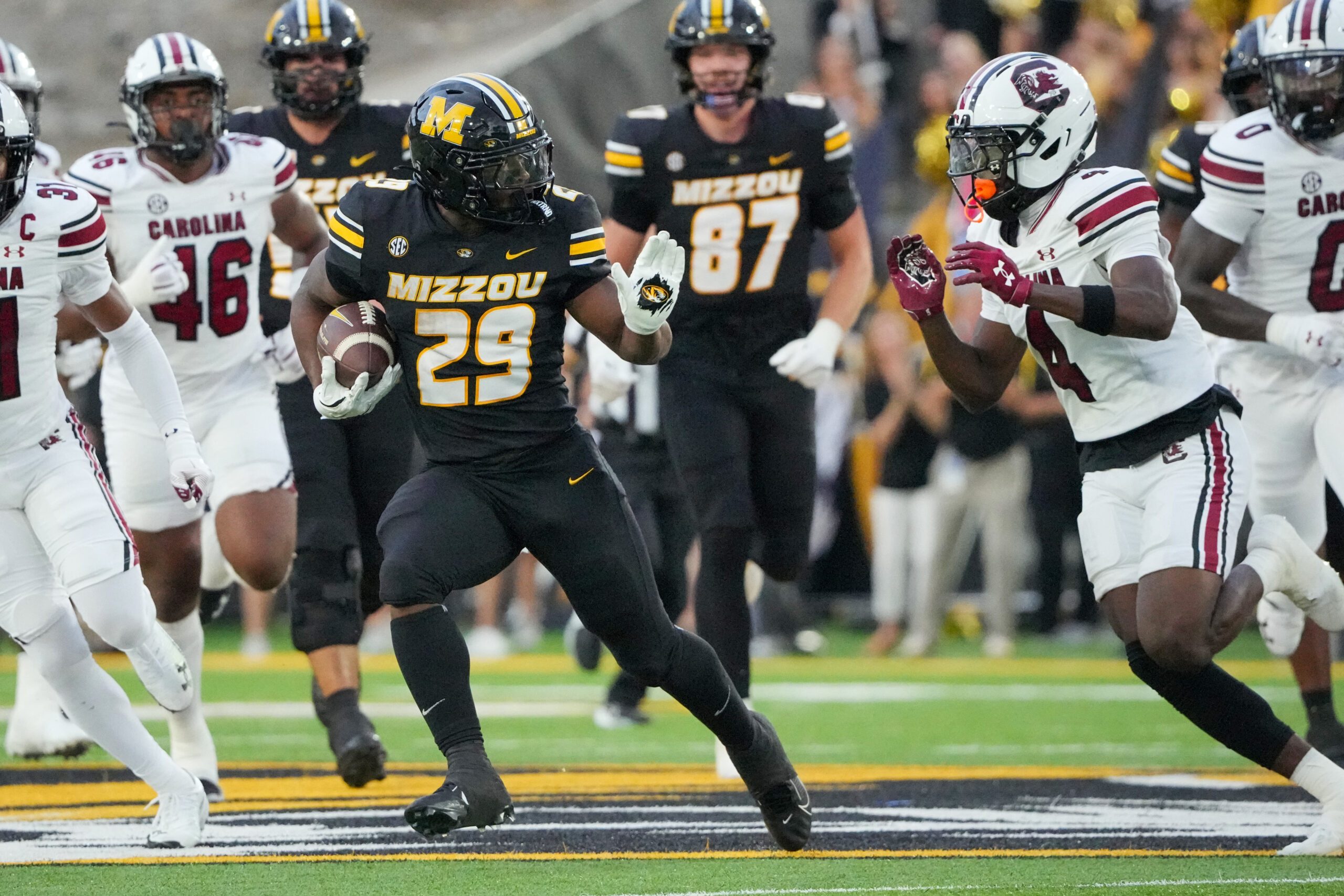 Sep 20, 2025; Columbia, Missouri, USA; Missouri Tigers running back Ahmad Hardy (29) runs the ball as South Carolina Gamecocks defensive back Vicari Swain (4) defends during the first half of the game at Faurot Field at Memorial Stadium. Mandatory Credit: Denny Medley-Imagn Images