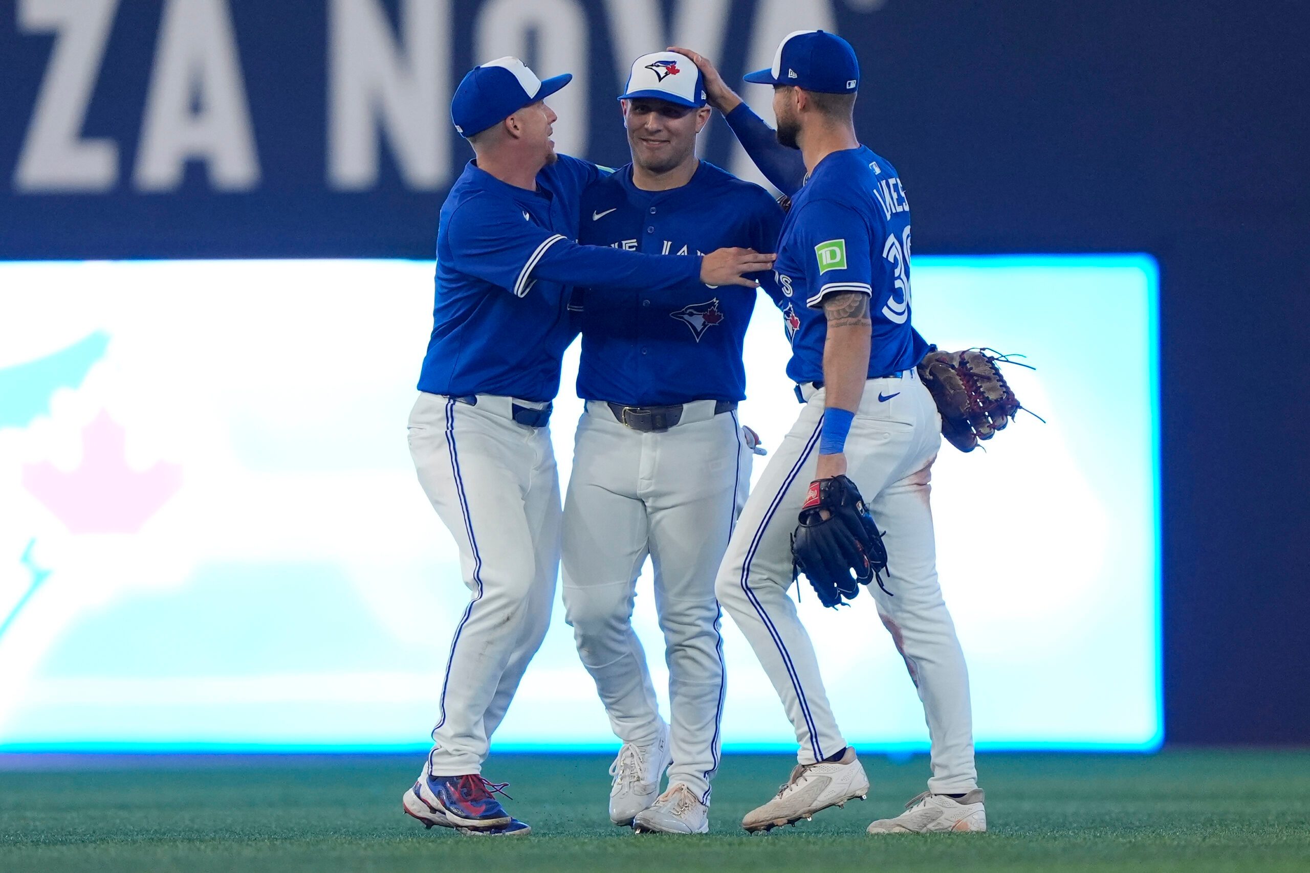 Sep 25, 2025; Toronto, Ontario, CAN; Toronto Blue Jays left fielder Anthony Santander (left) and center fielder Daulton Varsho (center) and right fielder Nathan Lukes (right) celebrate a win over the Boston Red Sox during the ninth inning at Rogers Centre. Mandatory Credit: John E. Sokolowski-Imagn Images
