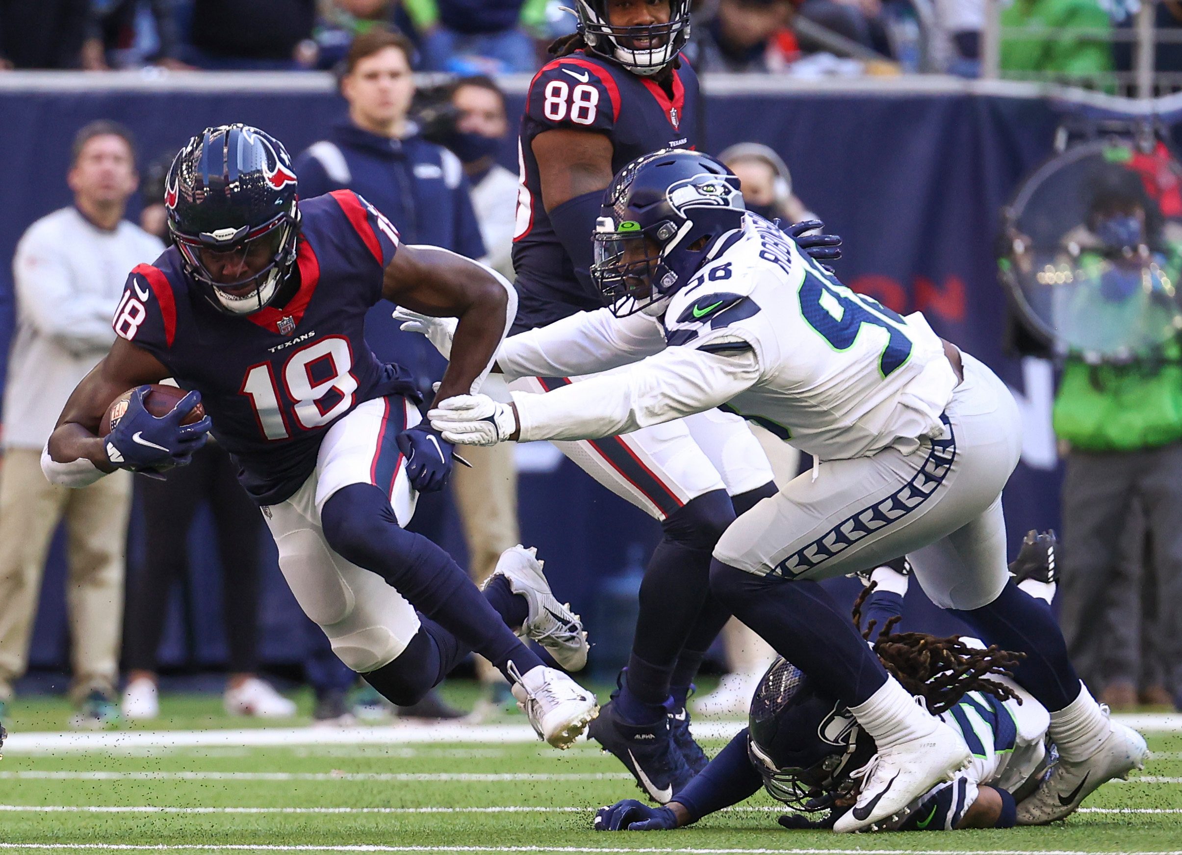 Dec 12, 2021; Houston, Texas, USA; Houston Texans wide receiver Chris Conley (18) makes a reception during the fourth quarter as Seattle Seahawks outside linebacker Alton Robinson (98) defends during the fourth quarter at NRG Stadium. Mandatory Credit: Troy Taormina-Imagn Images