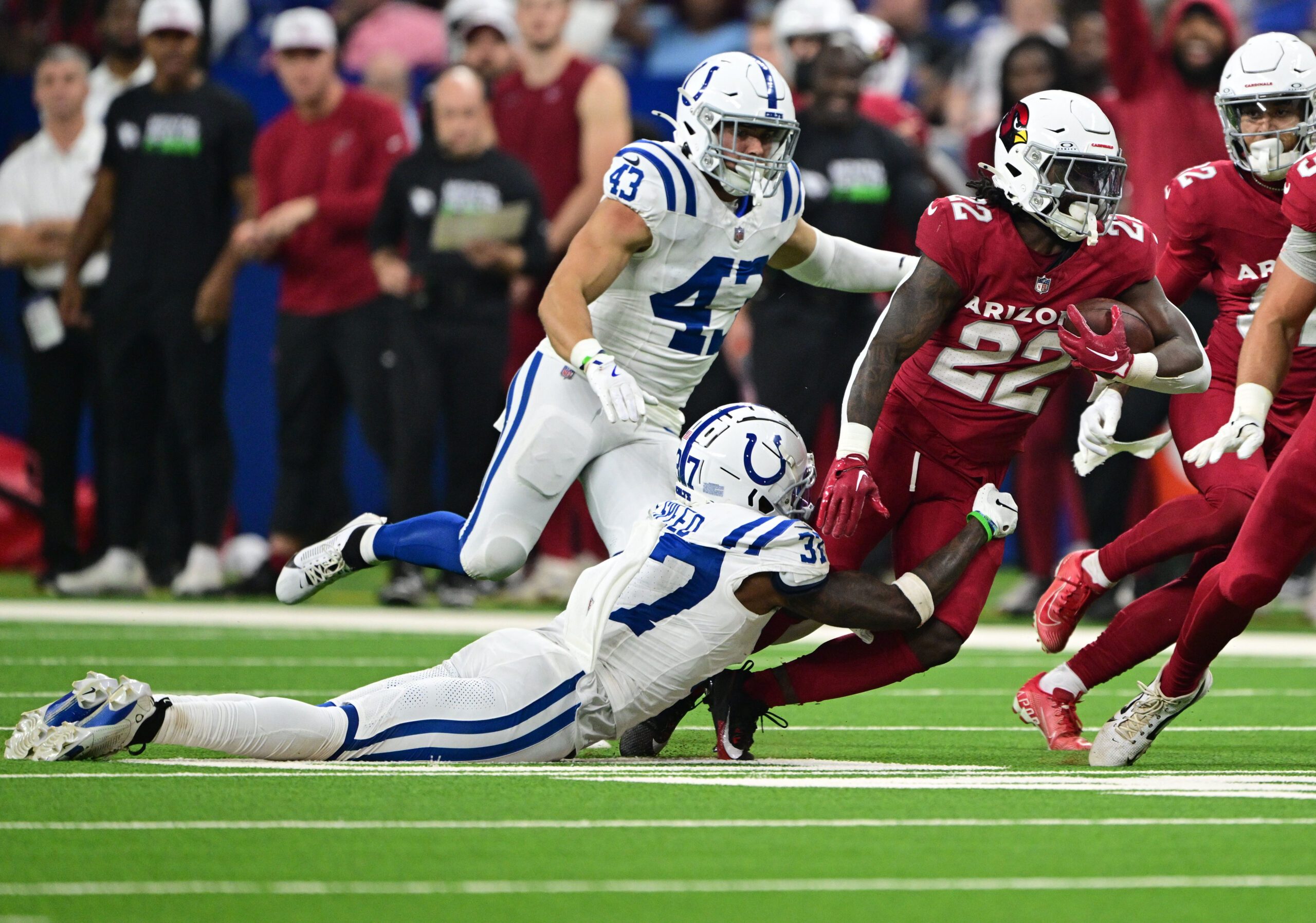 Aug 17, 2024; Indianapolis, Indiana, USA; Arizona Cardinals running back Michael Carter (22) is tackled by Indianapolis Colts cornerback Ameer Speed (37) during the second half at Lucas Oil Stadium. Mandatory Credit: Marc Lebryk-Imagn Images