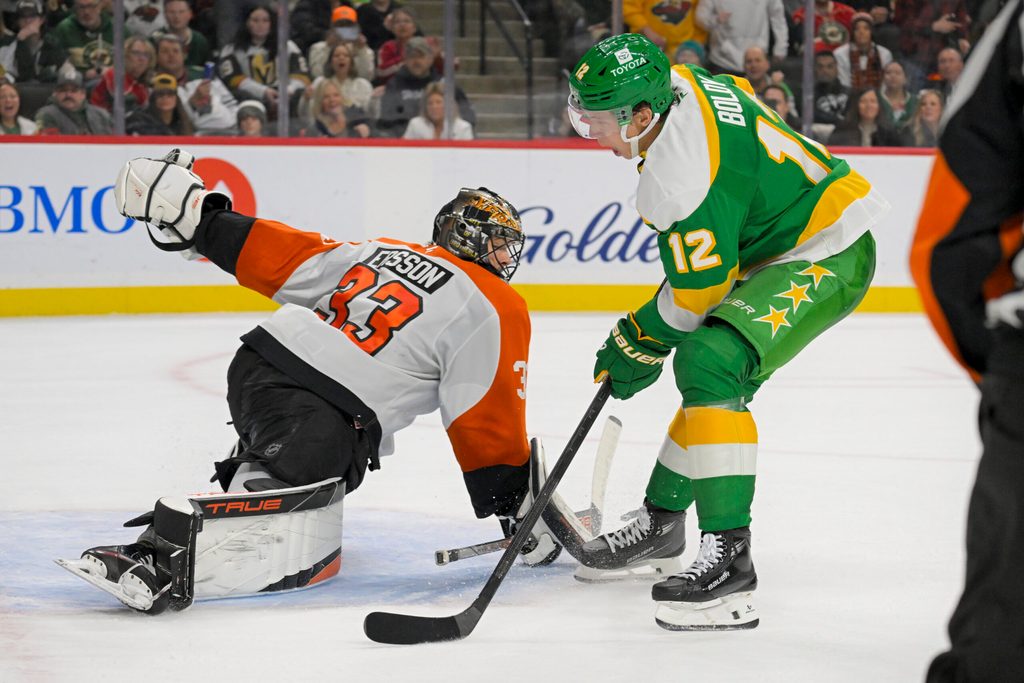 Dec 14, 2024; Saint Paul, Minnesota, USA; Minnesota Wild forward Matt Boldy (12) scores a breakaway goal against Philadelphia Flyers goalie Samuel Ersson (33) during the second period at Xcel Energy Center. Mandatory Credit: Nick Wosika-Imagn Images