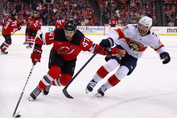 Jan 14, 2025; Newark, New Jersey, USA; New Jersey Devils center Paul Cotter (47) skates with the puck while being defended by Florida Panthers defenseman Dmitry Kulikov (7) during the second period at Prudential Center. Mandatory Credit: Ed Mulholland-Imagn Images