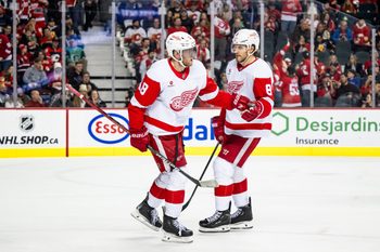Feb 1, 2025; Calgary, Alberta, CAN; Detroit Red Wings center Andrew Copp (18) celebrates with defenseman Ben Chiarot (8) after scoring an empty net goal against the Calgary Flames during the third period at Scotiabank Saddledome. Mandatory Credit: Brett Holmes-Imagn Images