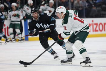 Feb 27, 2025; Salt Lake City, Utah, USA; Minnesota Wild left wing Matt Boldy (12) moves the puck against Utah Hockey Club center Nick Schmaltz (8) during the third period at Delta Center. Mandatory Credit: Rob Gray-Imagn Images