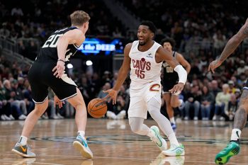 Mar 9, 2025; Milwaukee, Wisconsin, USA; Cleveland Cavaliers guard Donovan Mitchell (45) drives against Milwaukee Bucks guard AJ Green (20) in the first half at Fiserv Forum. Mandatory Credit: Michael McLoone-Imagn Images