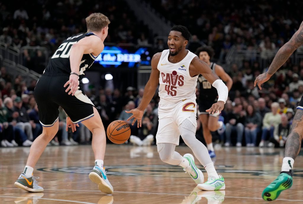 Mar 9, 2025; Milwaukee, Wisconsin, USA; Cleveland Cavaliers guard Donovan Mitchell (45) drives against Milwaukee Bucks guard AJ Green (20) in the first half at Fiserv Forum. Mandatory Credit: Michael McLoone-Imagn Images