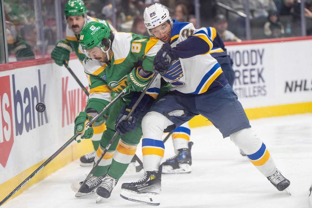 Mar 15, 2025; Saint Paul, Minnesota, USA; St. Louis Blues center Jordan Kyrou (25) catches the elbow of Minnesota Wild center Frederick Gaudreau (89) while playing the puck behind the Minnesota Wild net in the first period at Xcel Energy Center. Mandatory Credit: Matt Blewett-Imagn Images