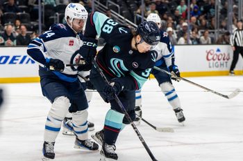 Mar 16, 2025; Seattle, Washington, USA;  Seattle Kraken foward Jani Nyman (38) skates against Winnipeg Jets defenseman Josh Morrissey (44) at Climate Pledge Arena. Mandatory Credit: Stephen Brashear-Imagn Images