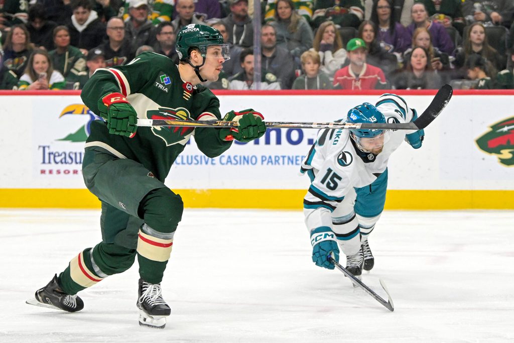 Apr 9, 2025; Saint Paul, Minnesota, USA; Minnesota Wild forward Joel Eriksson Ek (14) scores his fourth goal of the night as San Jose Sharks forward Nikolai Kovalenko (15) defends during the third period at Xcel Energy Center. Mandatory Credit: Nick Wosika-Imagn Images