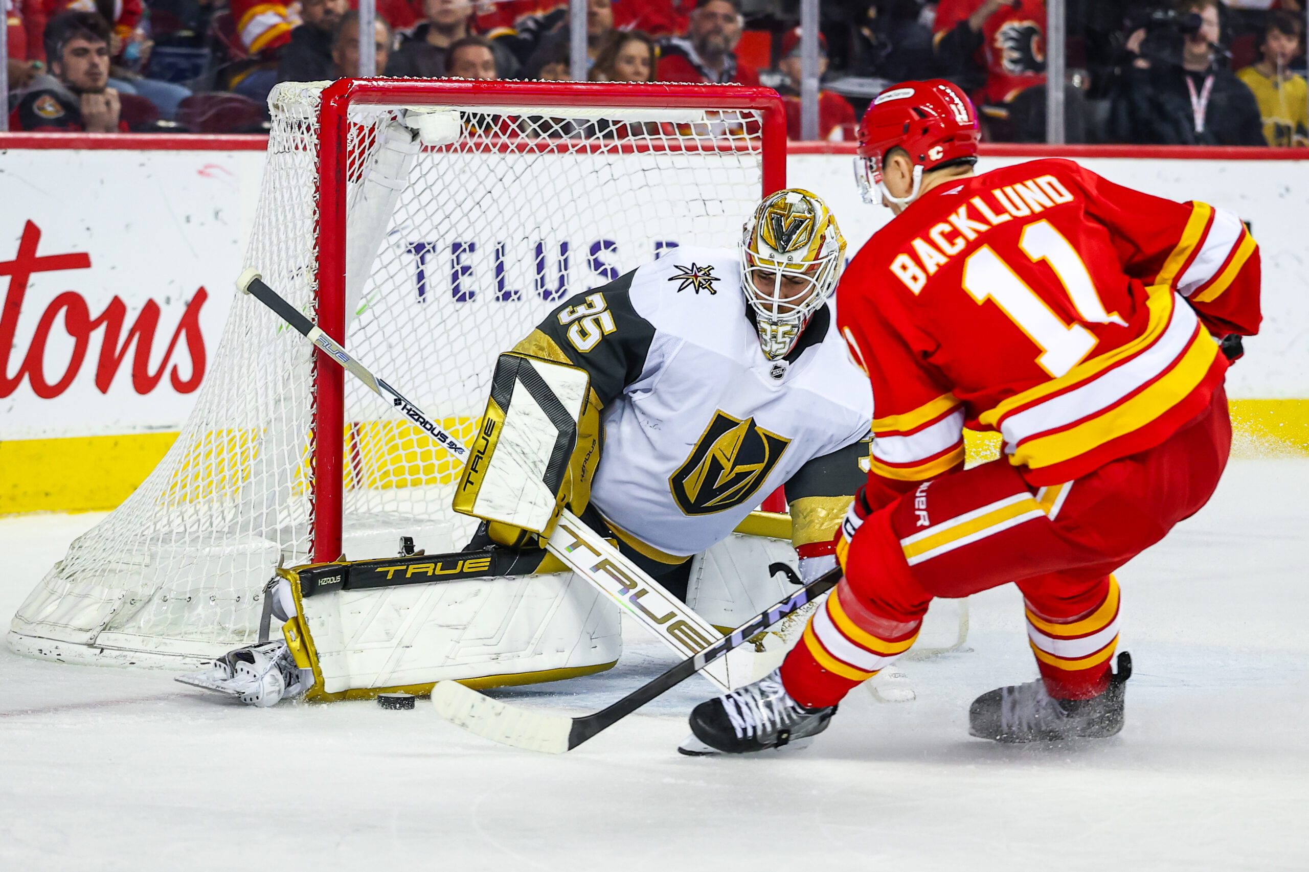 Apr 15, 2025; Calgary, Alberta, CAN; Vegas Golden Knights goaltender Ilya Samsonov (35) makes a save against Calgary Flames center Mikael Backlund (11) during the overtime period at Scotiabank Saddledome. Mandatory Credit: Sergei Belski-Imagn Images
