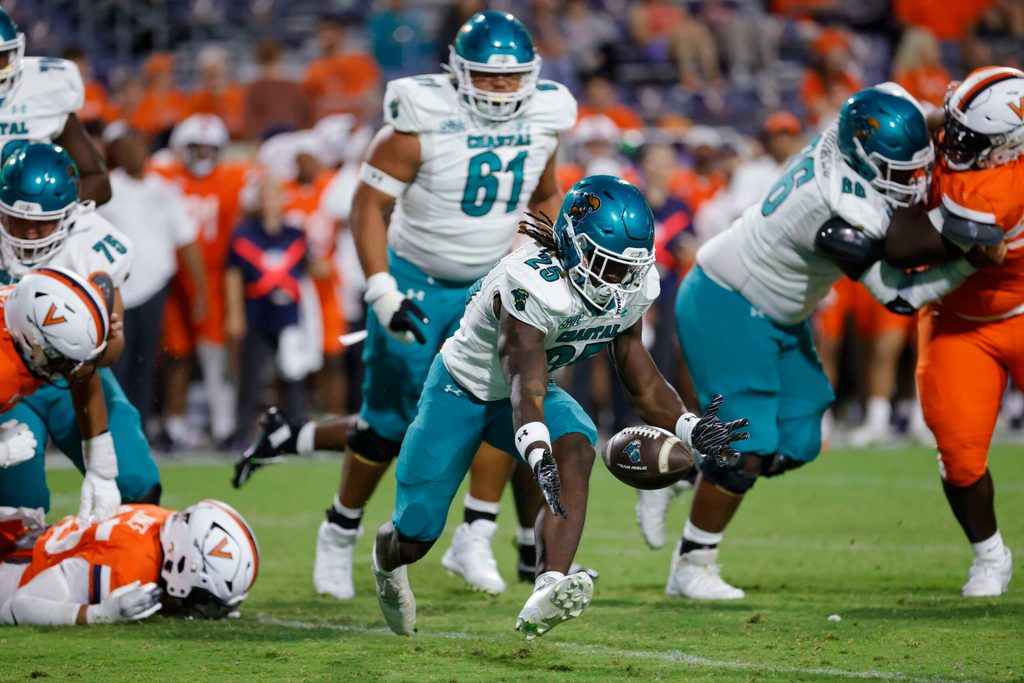 Aug 30, 2025; Charlottesville, Virginia, USA; Coastal Carolina Chanticleers running back Breyahn Townsend (25) attempts to recover a fumble against the Virginia Cavaliers during the second half at Scott Stadium. Mandatory Credit: Amber Searls-Imagn Images