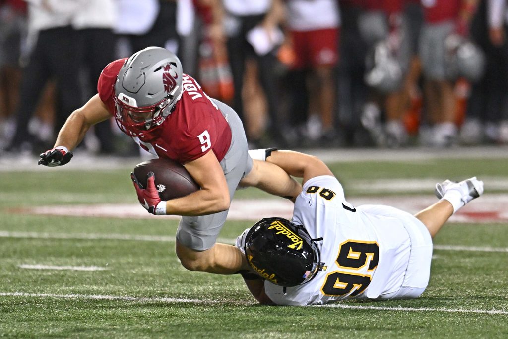 Aug 30, 2025; Pullman, Washington, USA; Washington State Cougars running back Kirby Vorhees (9) is tackled in the backfield by Idaho Vandals defensive lineman Trevor Miller (99) in the first half at Gesa Field at Martin Stadium. Mandatory Credit: James Snook-Imagn Images
