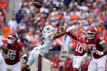 Oklahoma Sooners quarterback John Mateer (10) is hit by Auburn Tigers defensive end Keldric Faulk (15) as he throws in the first quarter of a college football game between the University of Oklahoma Sooners (OU) and the Auburn Tigers at Gaylord Family Ð Oklahoma Memorial Stadium in Norman, Okla., Saturday,Sept. 20, 2025. Oklahoma won 24-17.