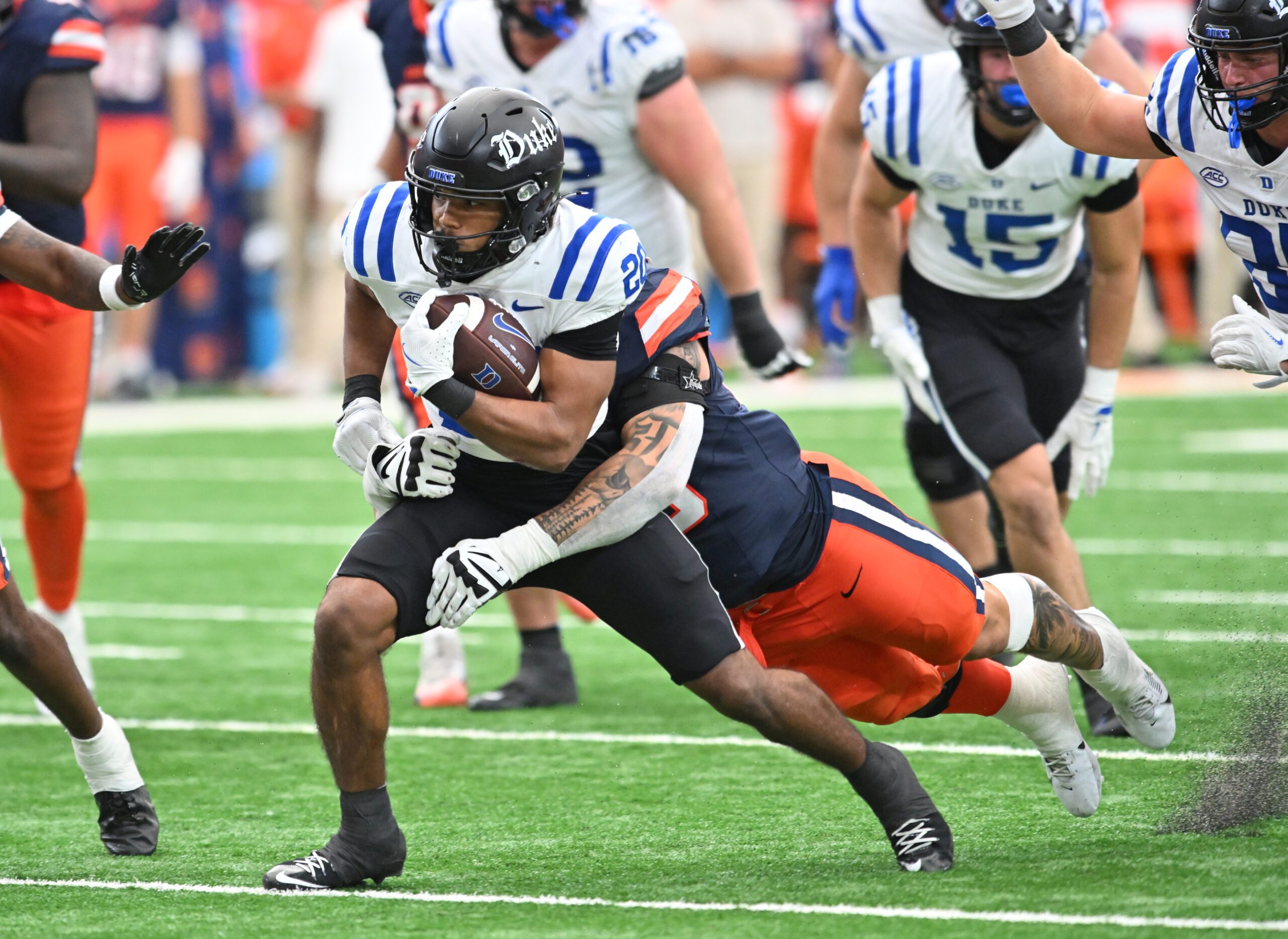 Sep 27, 2025; Syracuse, New York, USA; Duke Blue Devils running back Nate Sheppard (20) tries to break a tackle by Syracuse Orange defensive lineman Nathan Nyandoro (30) in the fourth quarter at the JMA Wireless Dome. Mandatory Credit: Mark Konezny-Imagn Images