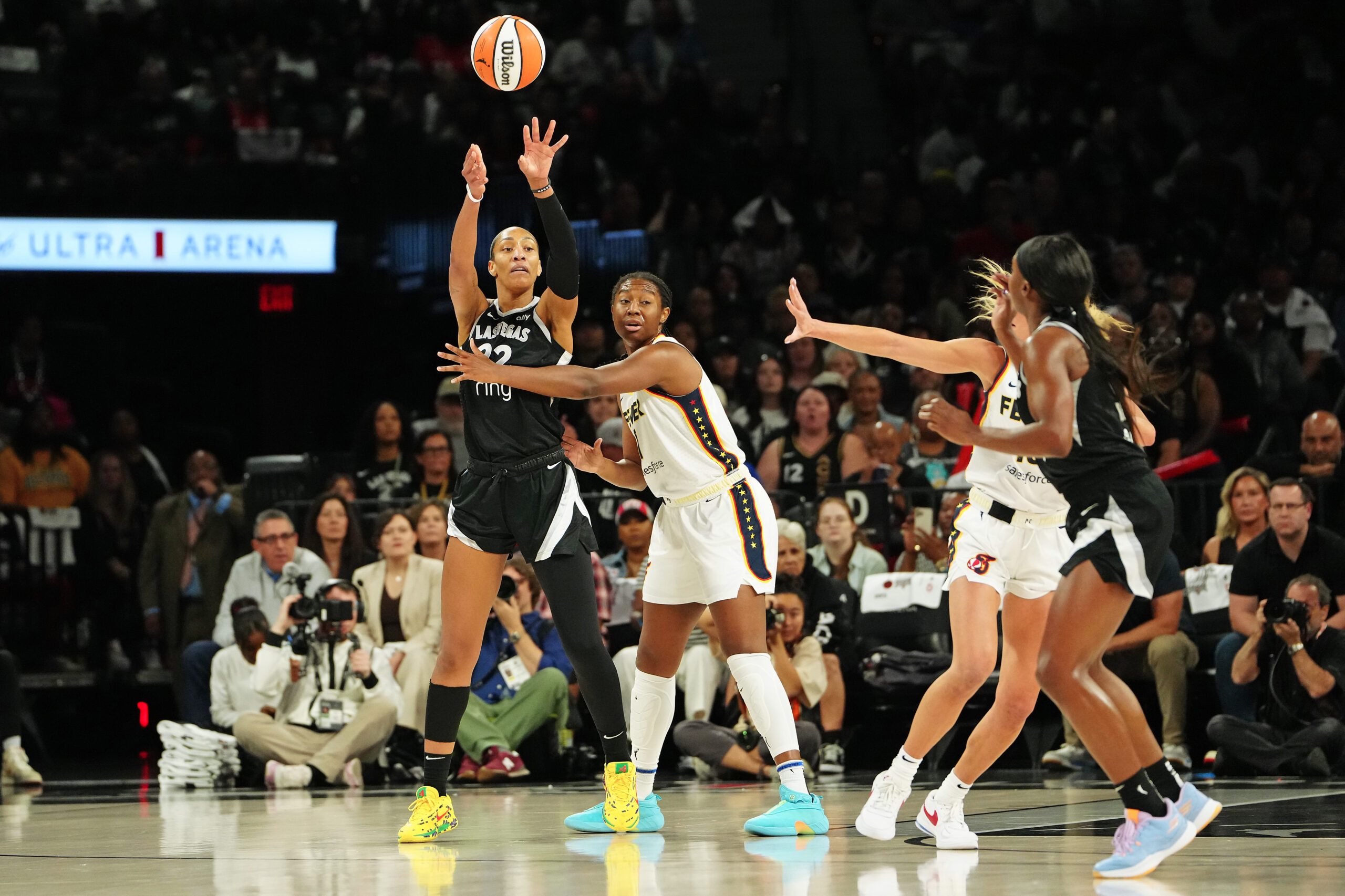 Sep 30, 2025; Las Vegas, Nevada, USA; Las Vegas Aces center A'ja Wilson (22) passes the ball over the defense of Indiana Fever guard Odyssey Sims (1) during the first quarter of game five of the second round for the 2025 WNBA Playoffs at Michelob Ultra Arena. Mandatory Credit: Stephen R. Sylvanie-Imagn Images