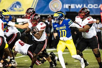 Western Kentucky running back Marvis Parrish (21) runs the ball, with offensive lineman Quincy Jenkins (63) providing cover, against Delaware Blue Hens linebacker Blake Matthews (10) during Delaware's first home CUSA football game, which was nationally televised, at Delaware Stadium in Newark on Oct. 3, 2025. Western Kentucky won 27-24.