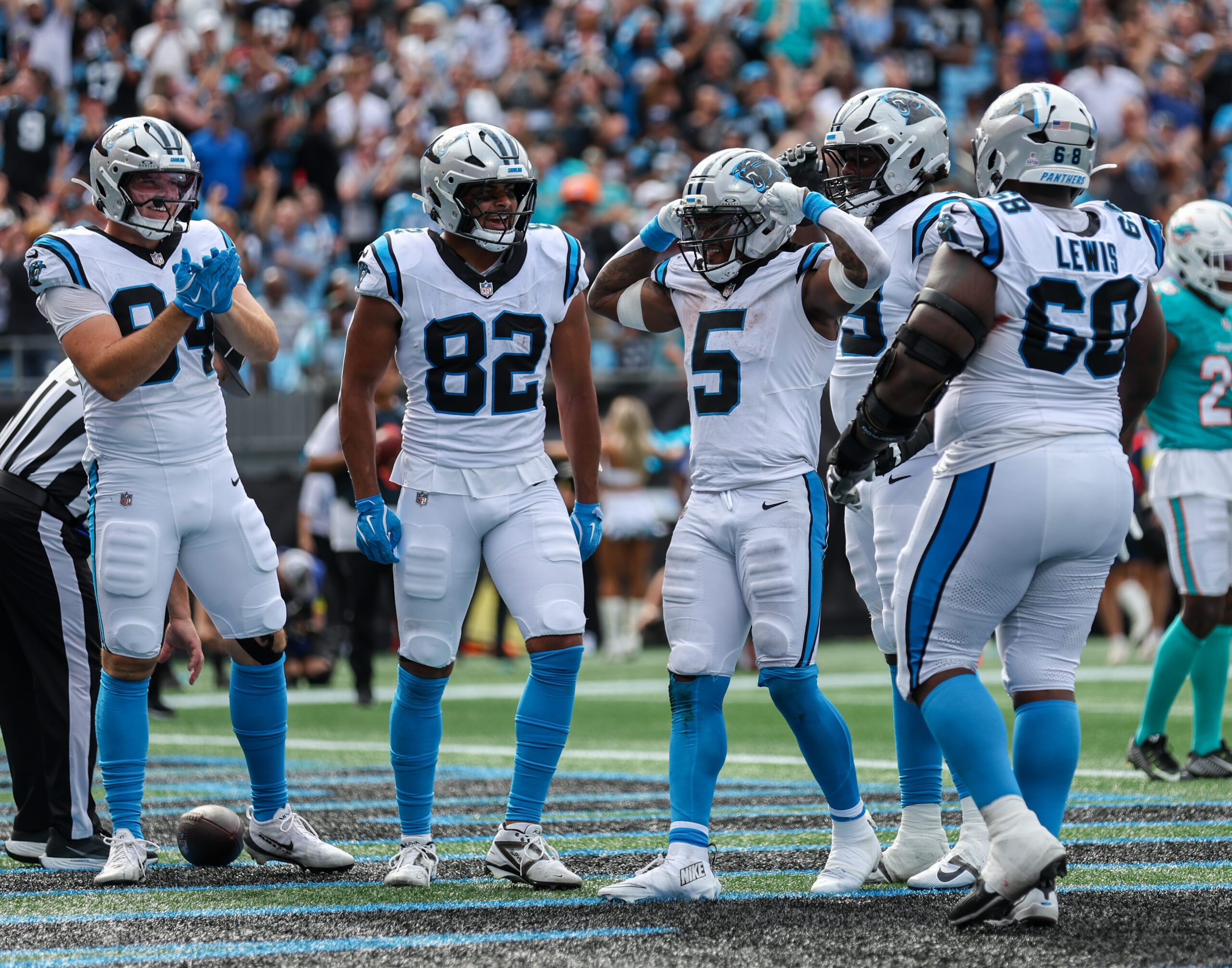 Oct 5, 2025; Charlotte, North Carolina, USA; Carolina Panthers running back Rico Dowdle (5) reacts after scoring a touchdown with Carolina Panthers tight end Tommy Tremble (82) and Carolina Panthers tight end Mitchell Evans (84) during the fourth quarter against the Miami Dolphins at Bank of America Stadium. Mandatory Credit: Cory Knowlton-Imagn Images