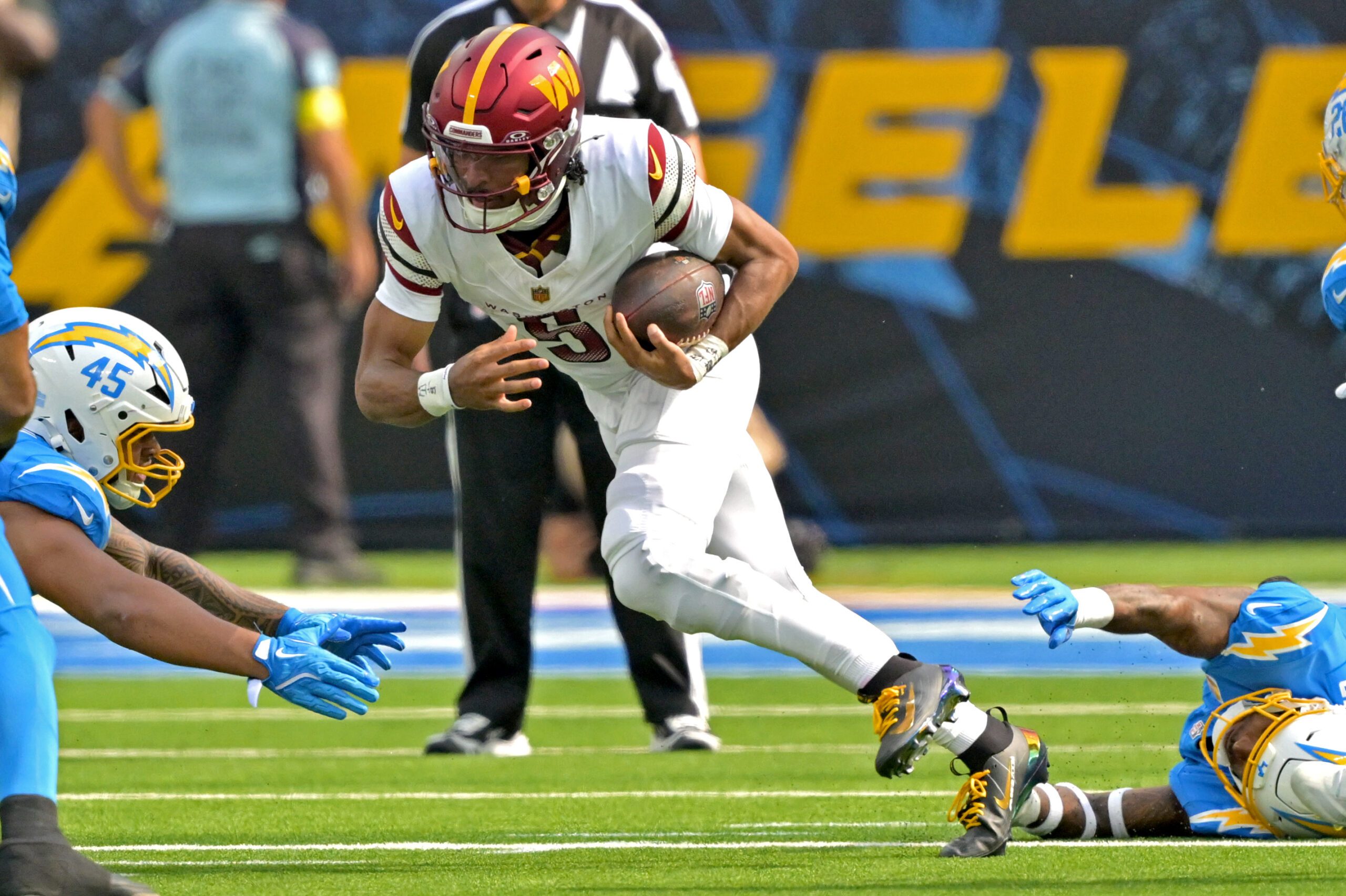 Oct 5, 2025; Inglewood, California, USA; Washington Commanders quarterback Jayden Daniels (5) runs for a first down against the Los Angeles Chargers at SoFi Stadium. Mandatory Credit: Jayne Kamin-Oncea-Imagn Images