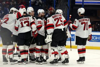 Oct 11, 2025; Tampa, Florida, USA; New Jersey Devils goaltender Jacob Markstrom (25), right wing Connor Brown (16), defenseman Jonas Siegenthaler (71) and teammates celebrate after they beat the Tampa Bay Lightning at Benchmark International Arena. Mandatory Credit: Kim Klement Neitzel-Imagn Images