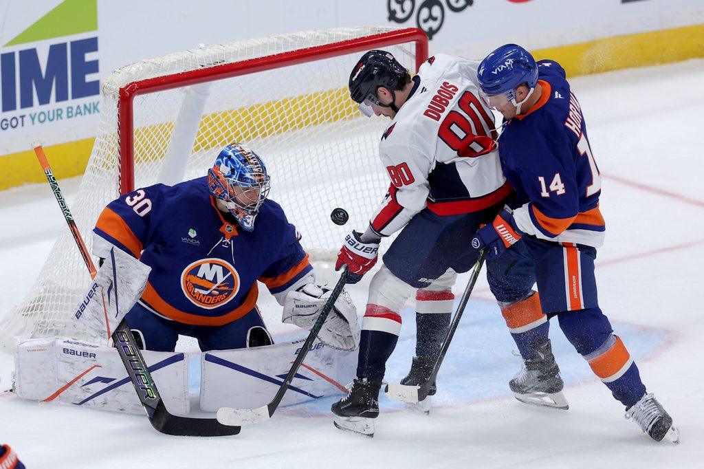 Oct 11, 2025; Elmont, New York, USA; Washington Capitals left wing Pierre-Luc Dubois (80) plays the puck against New York Islanders goaltender Ilya Sorokin (30) and center Bo Horvat (14) during the third period at UBS Arena. Mandatory Credit: Brad Penner-Imagn Images