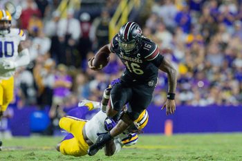Oct 11, 2025; Baton Rouge, Louisiana, USA;  LSU Tigers linebacker Harold Perkins Jr. (7) tackles South Carolina Gamecocks quarterback Lanorris Sellers (16) during the second half at Tiger Stadium. Mandatory Credit: Stephen Lew-Imagn Images