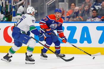Oct 11, 2025; Edmonton, Alberta, CAN; Edmonton Oilers forward Connor McDavid (97) looks to make a pass in front of Vancouver Canucks defensemen Filip Hornek (17) during the third period at Rogers Place. Mandatory Credit: Perry Nelson-Imagn Images