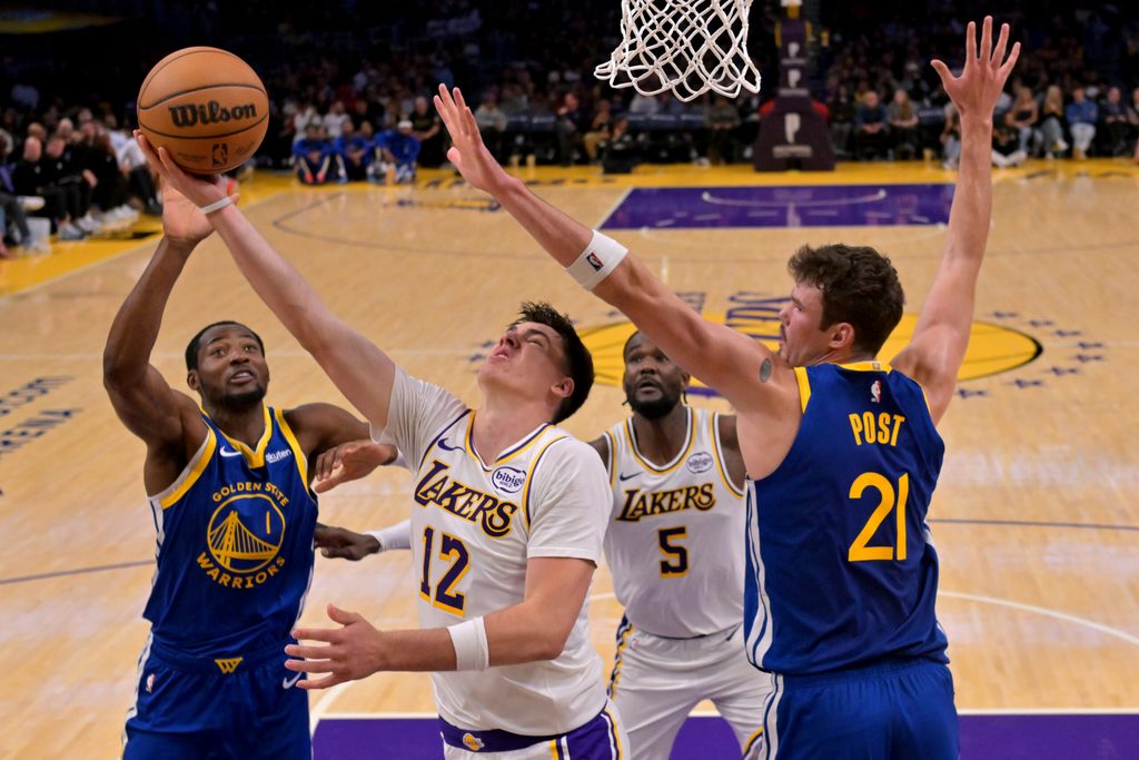 Oct 12, 2025; Los Angeles, California, USA; Los Angeles Lakers forward Jake Laravia (12) is defended by Golden State Warriors center Quinten Post (21) as he takes a shot during the second half at Crypto.com Arena. Mandatory Credit: Jayne Kamin-Oncea-Imagn Images