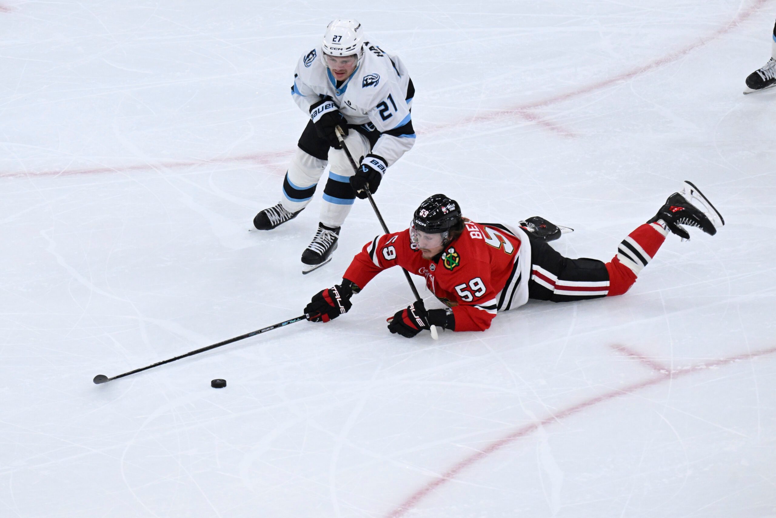 Oct 13, 2025; Chicago, Illinois, USA;  Chicago Blackhawks left wing Tyler Bertuzzi (59) and Utah Mammoth center Barrett Hayton (27) chase the puck during the second period at United Center. Mandatory Credit: Matt Marton-Imagn Images