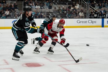 Oct 14, 2025; San Jose, California, USA;  San Jose Sharks center Ty Dellandrea (10) shoots the puck past Carolina Hurricanes center Seth Jarvis (24) during the first period at SAP Center at San Jose. Mandatory Credit: Stan Szeto-Imagn Images