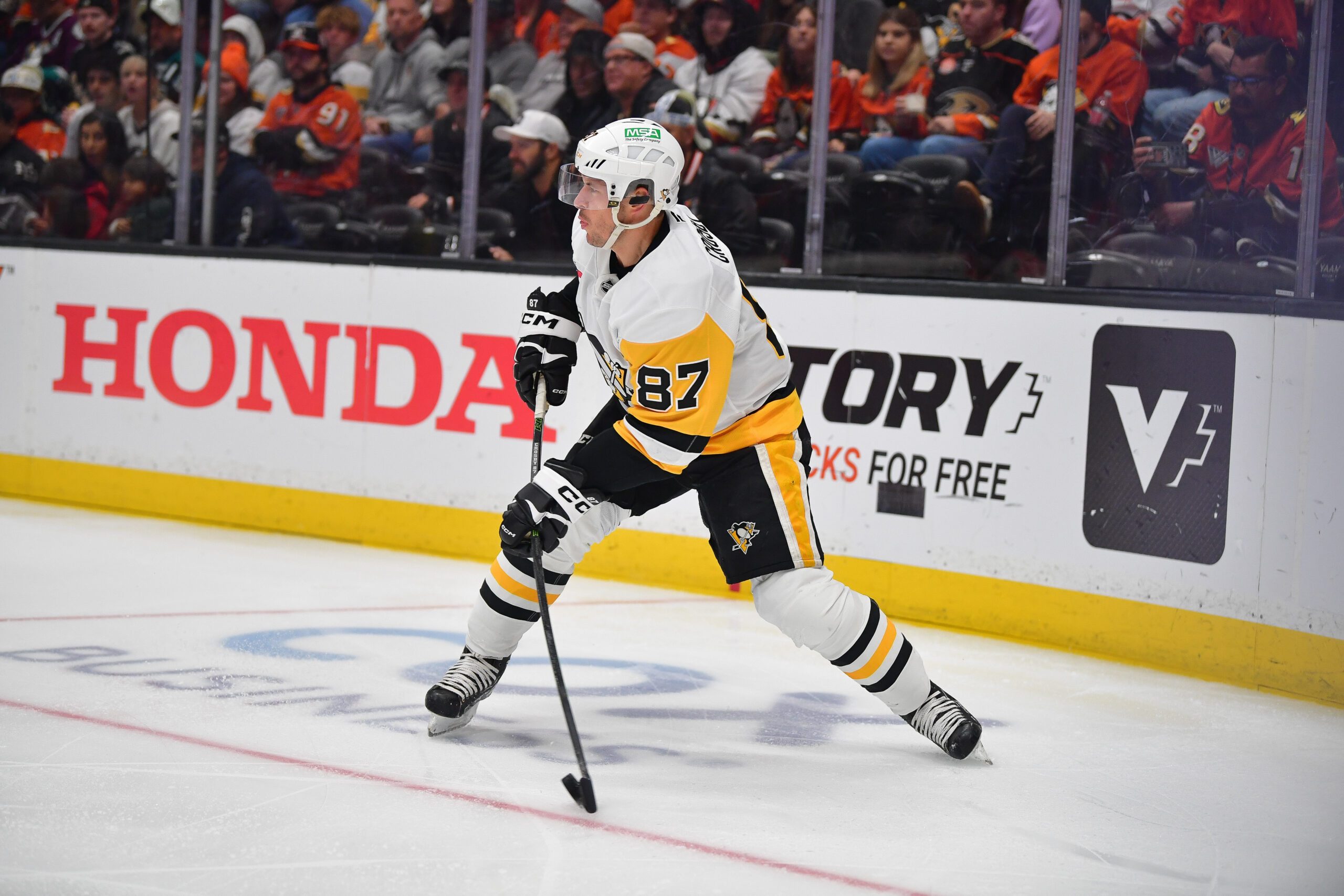 Oct 14, 2025; Anaheim, California, USA; Pittsburgh Penguins center Sidney Crosby (87) controls the puck against the Anaheim Ducks during the third period at Honda Center. Mandatory Credit: Gary A. Vasquez-Imagn Images