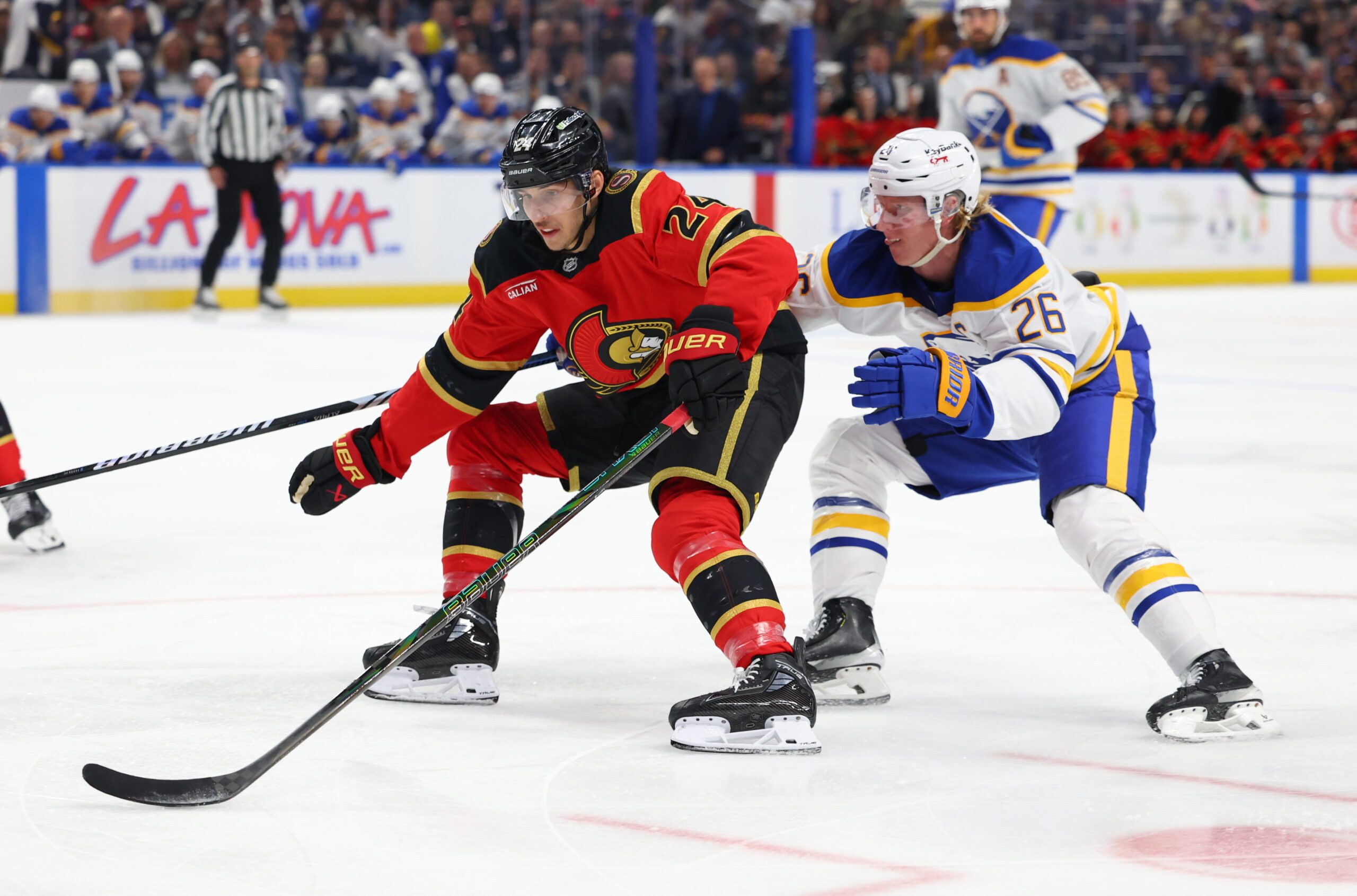 Oct 15, 2025; Buffalo, New York, USA;  Ottawa Senators center Dylan Cozens (24) skates to the net with the puck as Buffalo Sabres defenseman Rasmus Dahlin (26) defends during the first period at KeyBank Center. Mandatory Credit: Timothy T. Ludwig-Imagn Images
