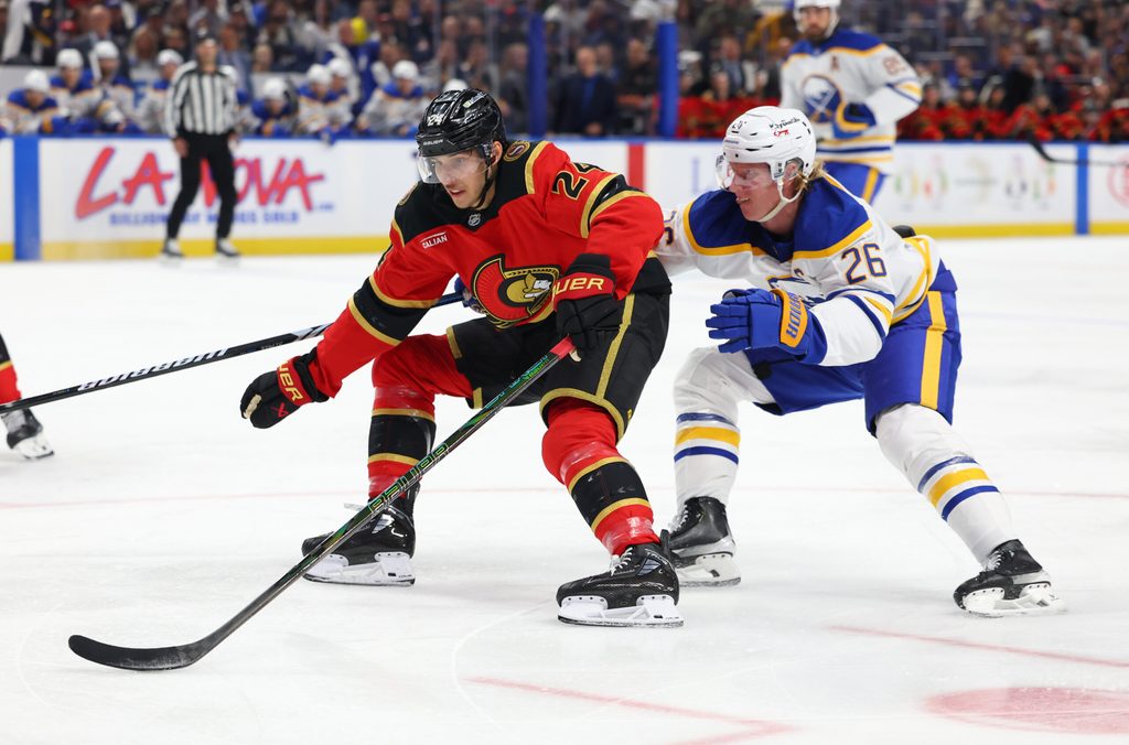 Oct 15, 2025; Buffalo, New York, USA; Ottawa Senators center Dylan Cozens (24) skates to the net with the puck as Buffalo Sabres defenseman Rasmus Dahlin (26) defends during the first period at KeyBank Center. Mandatory Credit: Timothy T. Ludwig-Imagn Images