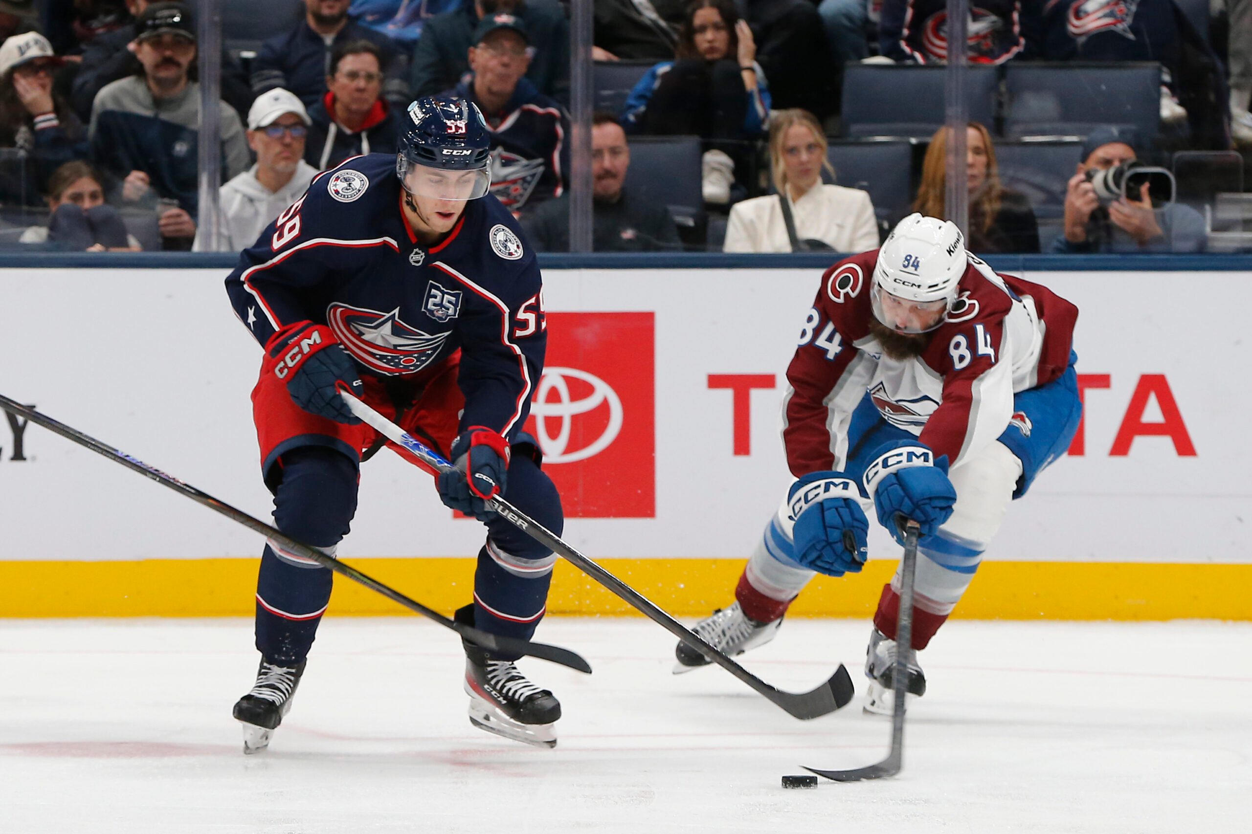 Oct 16, 2025; Columbus, Ohio, USA; Colorado Avalanche defenseman Brent Burns (84) reaches for the puck under the stick of Columbus Blue Jackets right wing Yegor Chinakhov (59) during the third period at Nationwide Arena. Mandatory Credit: Russell LaBounty-Imagn Images