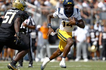 Oct 18, 2025; Orlando, Florida, USA; West Virginia Mountaineers quarterback Khalil Wilkins (14) runs the ball for a touchdown in the first half against the Central Florida Knights at Acrisure Bounce House. Mandatory Credit: Russell Lansford-Imagn Images