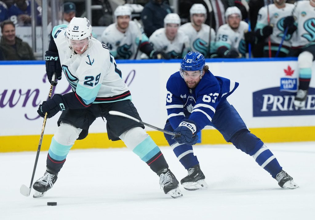 Oct 18, 2025; Toronto, Ontario, CAN; Seattle Kraken defenseman Vince Dunn (29) controls the puck defended by Toronto Maple Leafs left wing Matias MacCelli (63) during the third period at Scotiabank Arena. Mandatory Credit: Nick Turchiaro-Imagn Images
