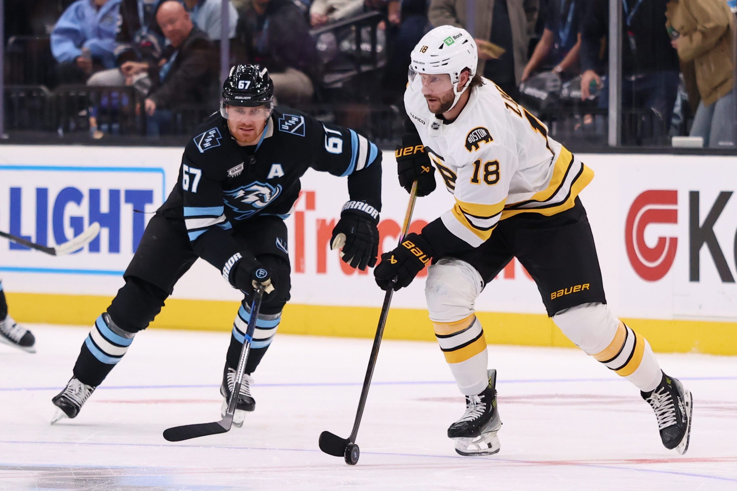 Oct 19, 2025; Salt Lake City, Utah, USA; Boston Bruins center Pavel Zacha (18) skates with the puck against Utah Mammoth left wing Lawson Crouse (67) during the second period at Delta Center. Mandatory Credit: Rob Gray-Imagn Images