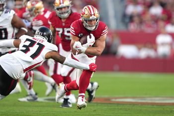 Oct 19, 2025; Santa Clara, California, USA; San Francisco 49ers running back Christian McCaffrey (center) carries the ball against Atlanta Falcons safety Xavier Watts (31) during the second quarter at Levi's Stadium. Mandatory Credit: Darren Yamashita-Imagn Images