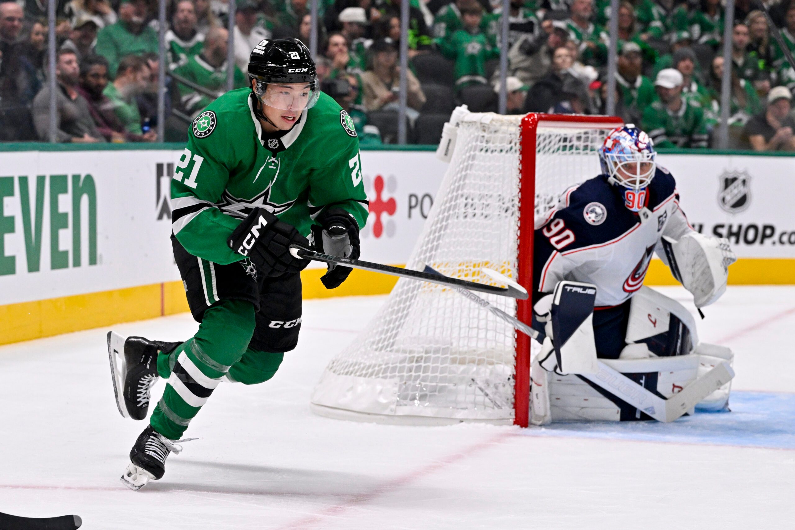 Oct 21, 2025; Dallas, Texas, USA; Dallas Stars left wing Jason Robertson (21) skates past Columbus Blue Jackets goaltender Elvis Merzlikins (90) during the game between the Stars and the Blue Jackets at the American Airlines Center. Mandatory Credit: Jerome Miron-Imagn Images