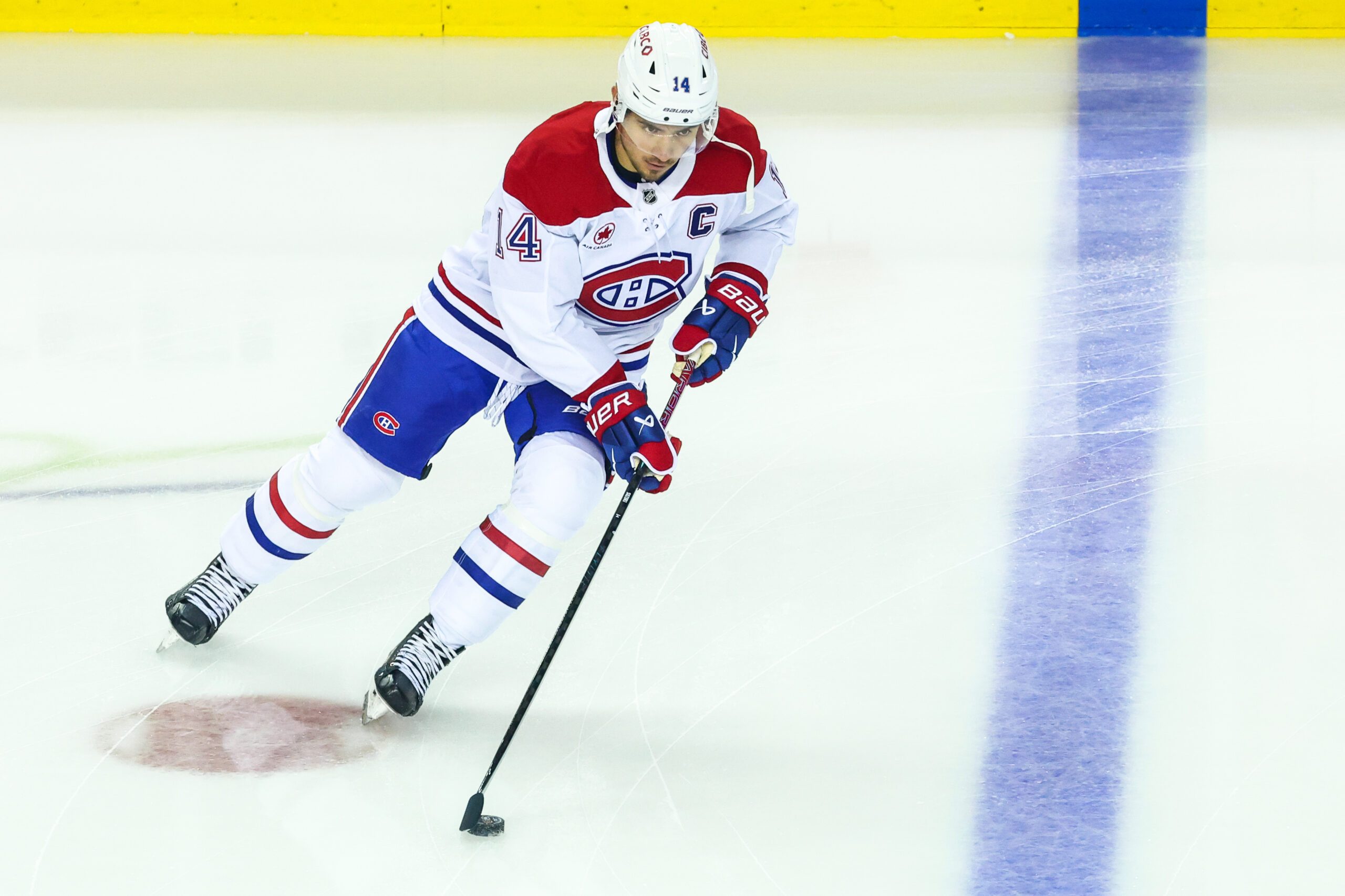 Oct 22, 2025; Calgary, Alberta, CAN; Montreal Canadiens center Nick Suzuki (14) skates with the puck during the warmup period against the Calgary Flames at Scotiabank Saddledome. Mandatory Credit: Sergei Belski-Imagn Images