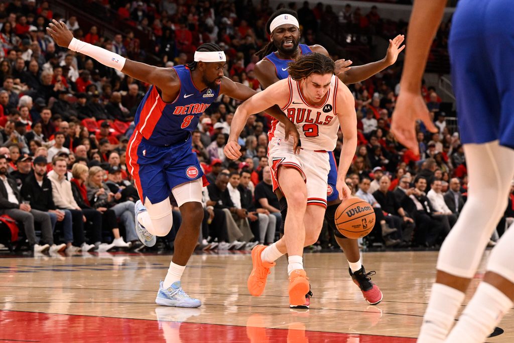 Oct 22, 2025; Chicago, Illinois, USA; Chicago Bulls guard Josh Giddey (3) drives between Detroit Pistons guard Caris LeVert (8) and forward Isaiah Stewart (28) during the first half at United Center. Mandatory Credit: Matt Marton-Imagn Images