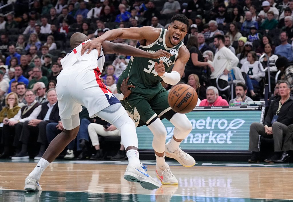 Oct 22, 2025; Milwaukee, Wisconsin, USA; Milwaukee Bucks forward Giannis Antetokounmpo (34) drives against Washington Wizards forward Khris Middleton (22) in the first half at Fiserv Forum. Mandatory Credit: Michael McLoone-Imagn Images