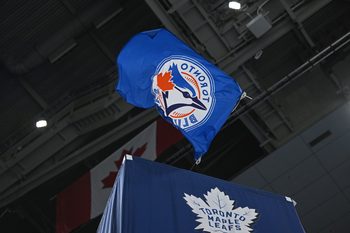 Oct 25, 2025; Toronto, Ontario, CAN; The Toronto Blue Jays flag is waved by the Toronto Maple Leafs against the Buffalo Sabres at Scotiabank Arena. Mandatory Credit: Gerry Angus-Imagn Images