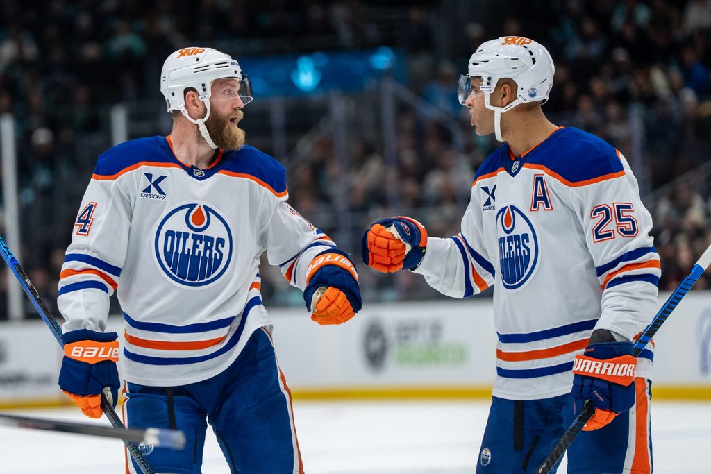 Oct 25, 2025; Seattle, Washington, USA; Edmonton Oilers defenseman Mattias Ekholm (14) and defenseman Darnell Nurse (25) celebrate after a goal during the third period against the Seattle Kraken at Climate Pledge Arena. Mandatory Credit: Stephen Brashear-Imagn Images