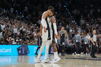 Oct 26, 2025; San Antonio, Texas, USA; San Antonio Spurs forward Victor Wembanyama (1) and San Antonio Spurs guard Devin Vassell (24) celebrate in the second half against the Brooklyn Nets at Frost Bank Center. Mandatory Credit: Daniel Dunn-Imagn Images