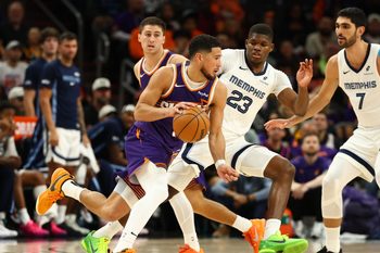 Oct 29, 2025; Phoenix, Arizona, USA; Phoenix Suns guard Devin Booker (1) moves the ball against Memphis Grizzlies forward Cedric Coward (23) during the second half at the Mortgage Matchup Center. Mandatory Credit: Mark J. Rebilas-Imagn Images