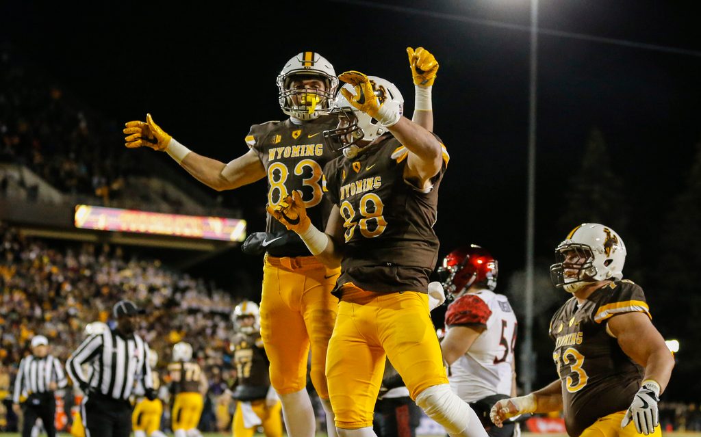 Dec 3, 2016; Laramie, WY, USA; Wyoming Cowboys tight end Jacob Hollister (88) and Jake Maulhardt (83) celebrate a touchdown against San Diego State Aztecs safety Malik Smith (12) during the first quarter at the Mountain West Championship college football game at War Memorial Stadium. Mandatory Credit: Troy Babbitt-Imagn Images